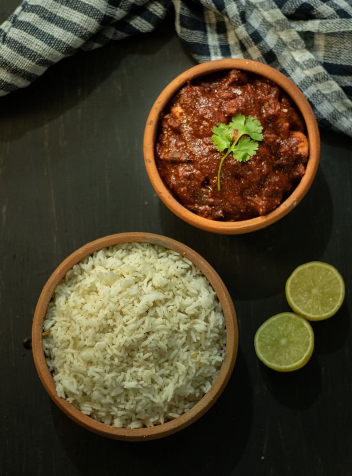 Home Top view of flavorful Indian curry with rice, captured in a rustic setting for a savory culinary experience.